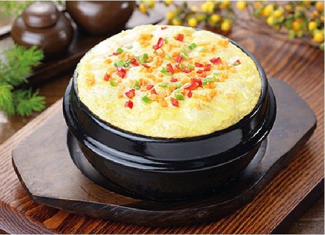 石皿に盛り付けた韓国風の一品料理と薬味、小鉢が並ぶ卓上