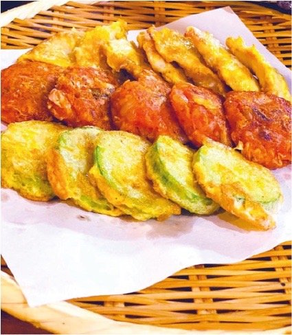 炭火の焼き網の上で肉を返す手元と立ちのぼる湯気